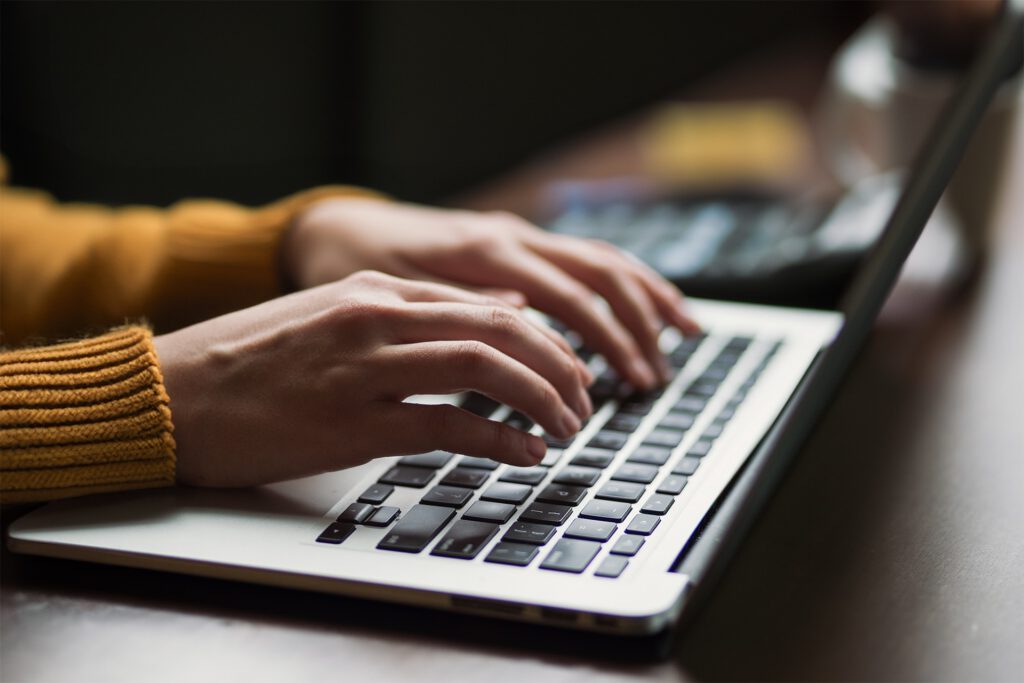 Person arbeitet an Laptop mit Taschenrechner im Hintergrund, Themen Preisrecht und Zuwendungsrecht